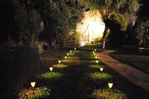 Camí del jardí il·luminat amb petits fanals fins a l'espai de la cerimònia, de nit