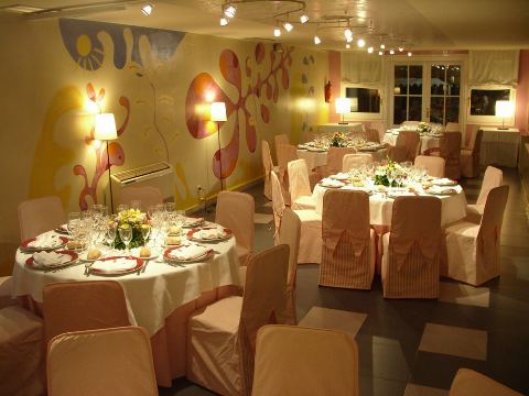 Sala amb paret decorada amb motius vegetals i taules rodones parades