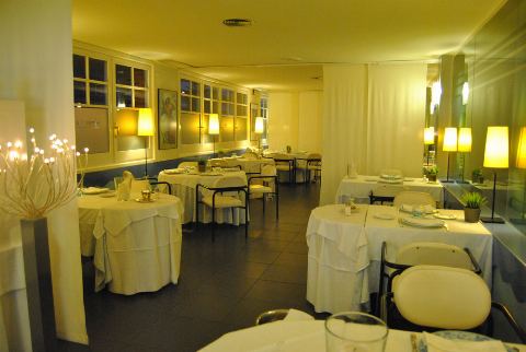 Sala amb làmpades de peu i taules parades vora els finestrals