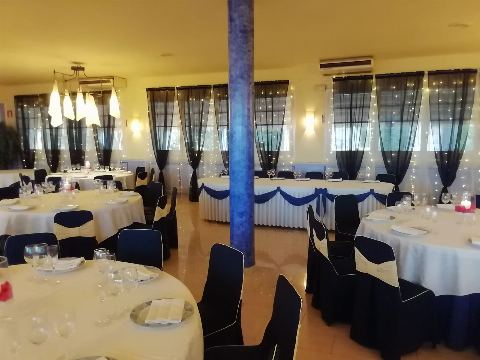 Sala amb columna blava, taula presidencial i taules rodones al fons